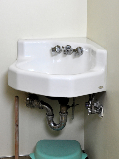 how to hide pipes under corner sink
