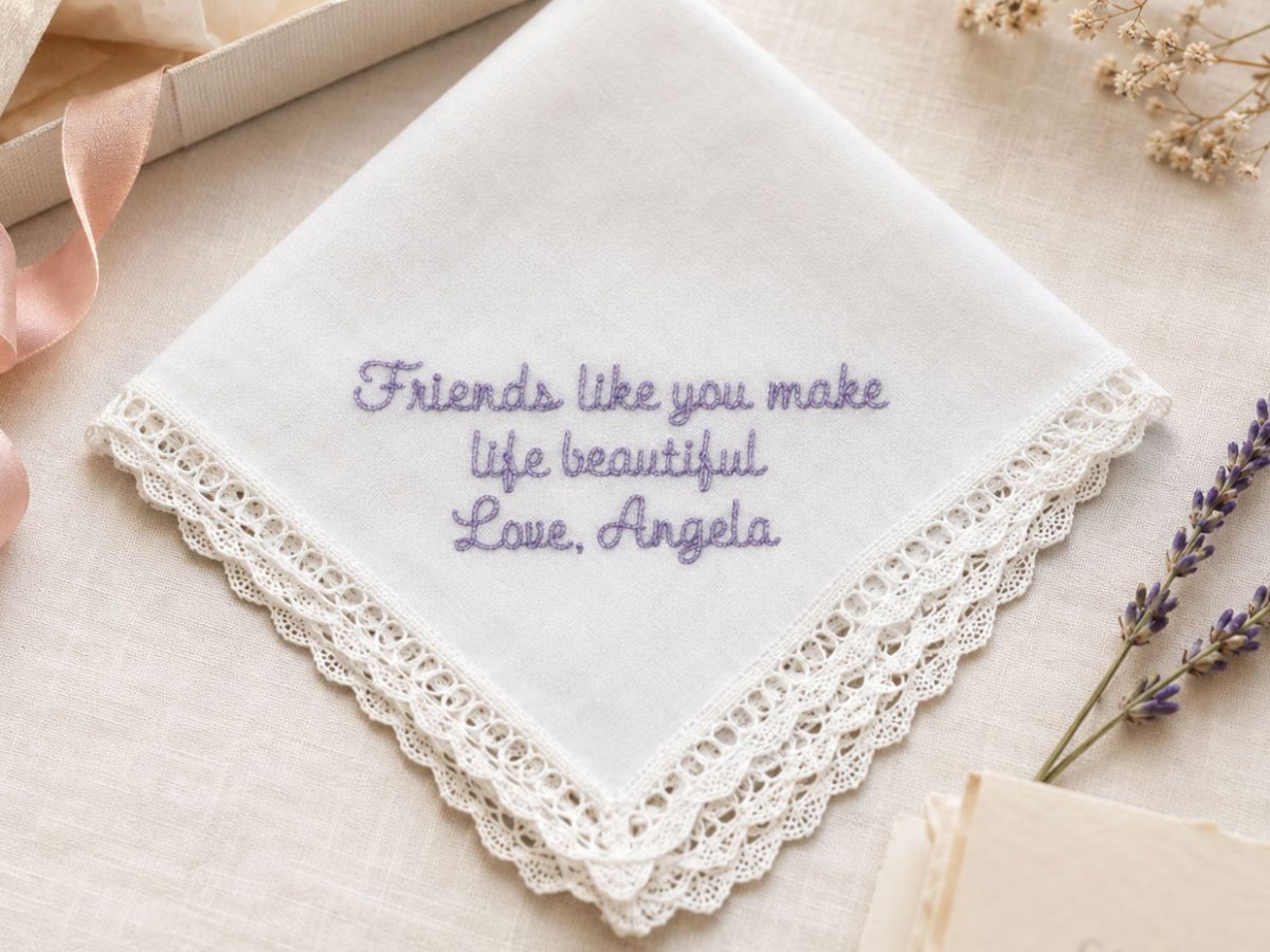 A white handkerchief with a crochet lace edge, embroidered in lilac thread: Friends like you make life beautiful, Love, Angela